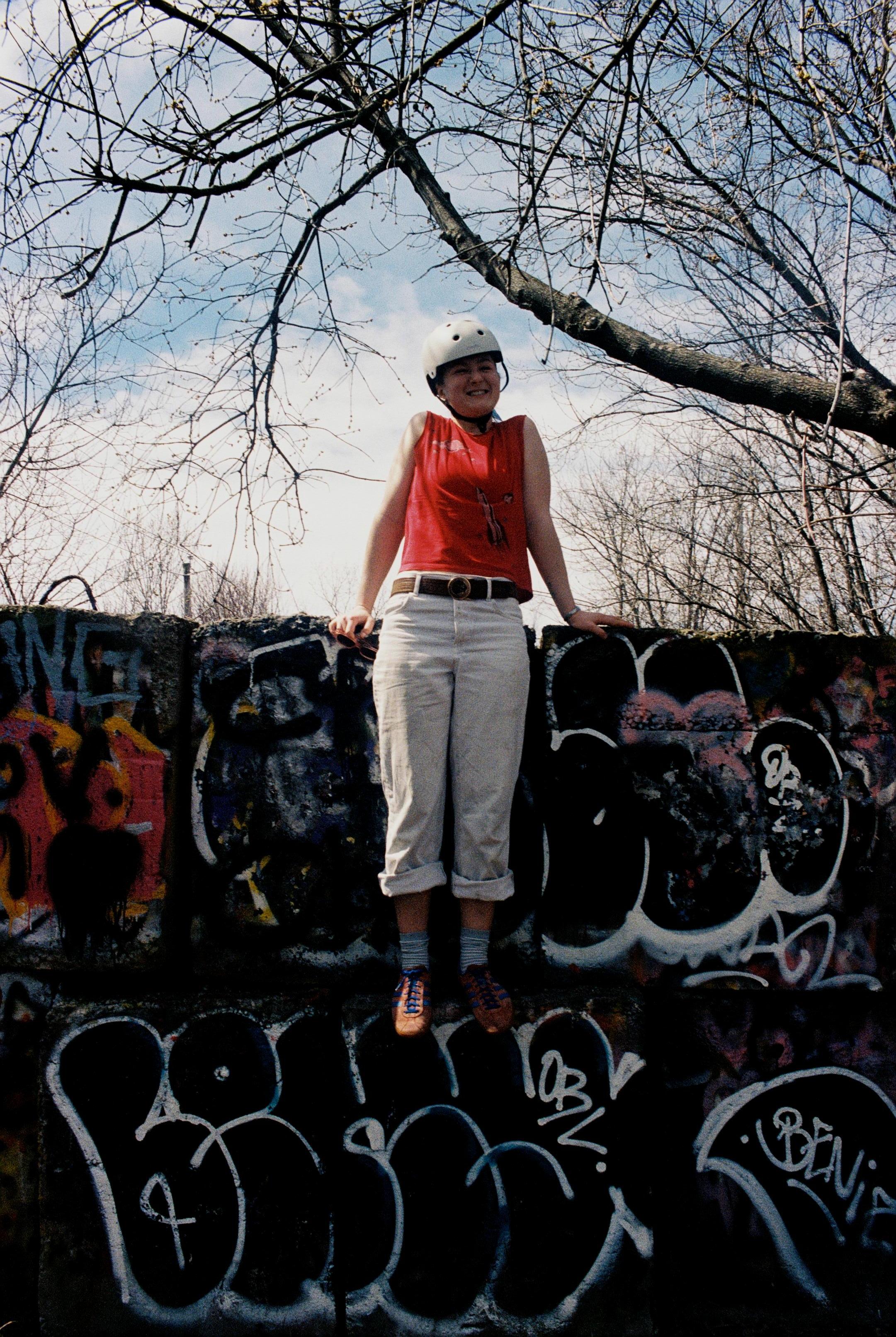 Young woman on graffitied concrete blocks