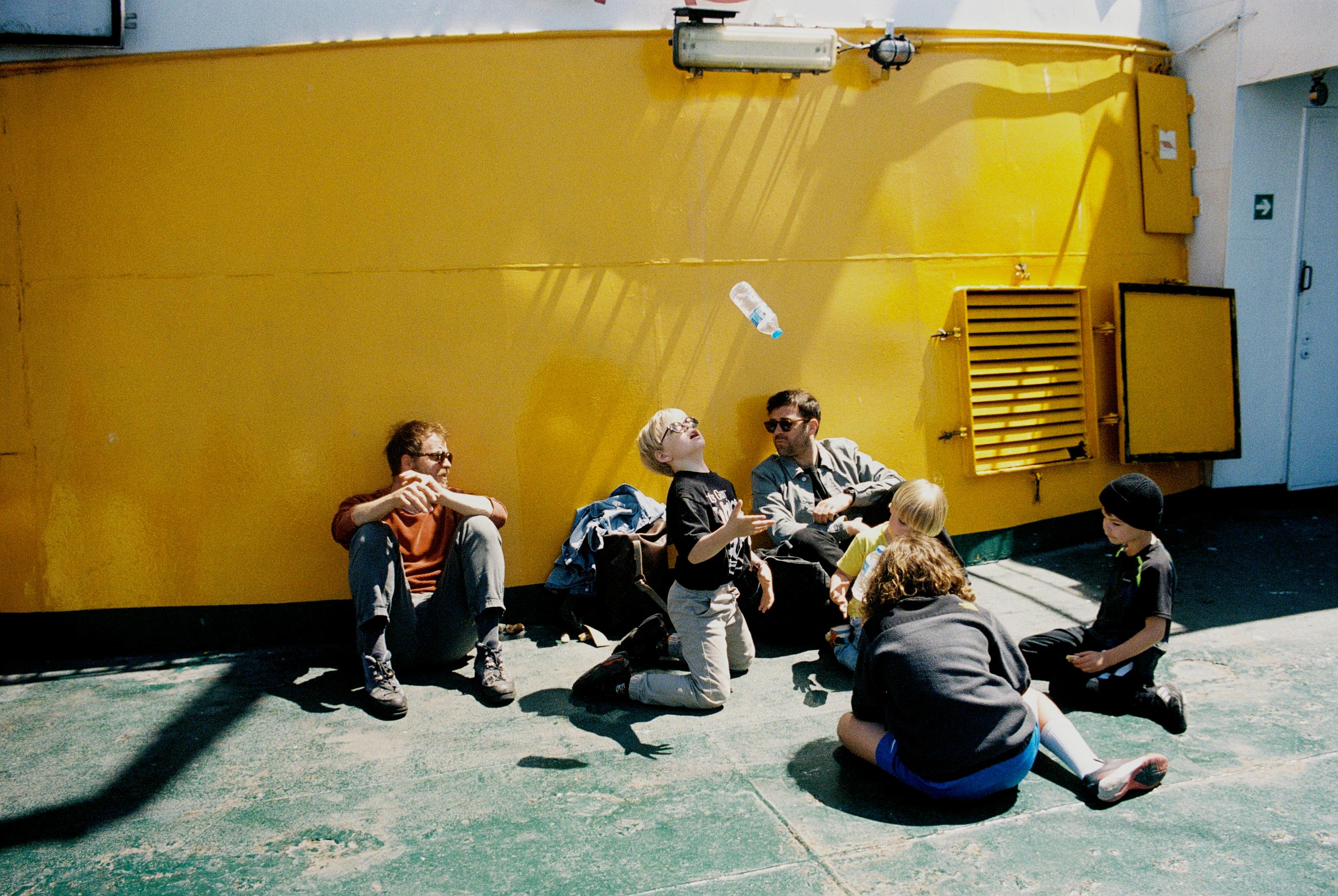 Boy with his family on a ferry flipping a bottle